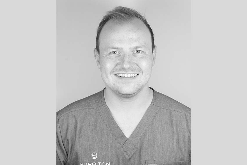 Black and white headshot portrait of Dr Wiktor at Surbiton Dental