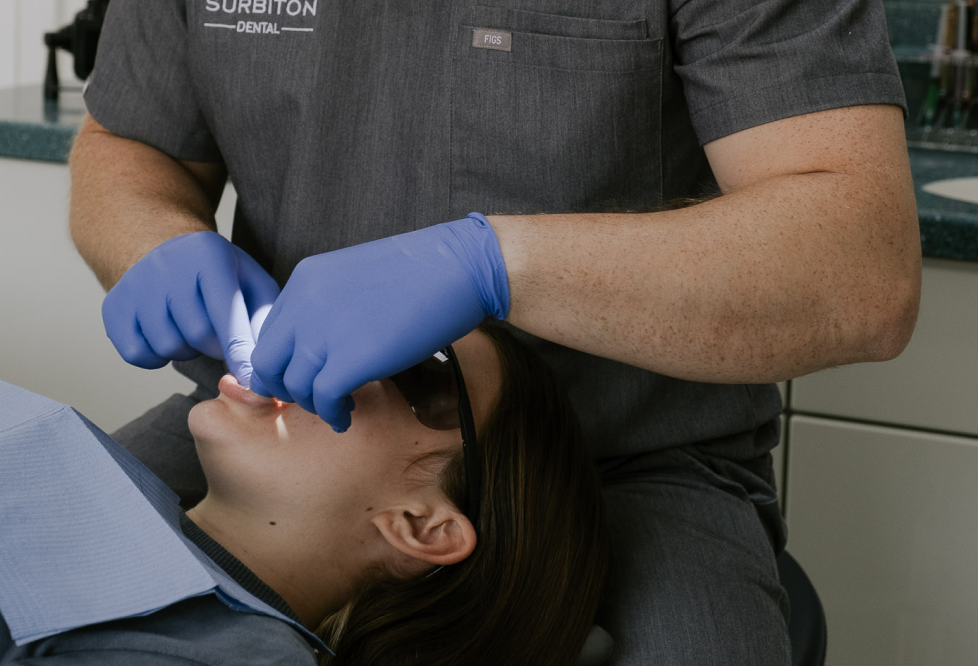 Close-up of dentist performing an oral assessment on a patient in the dental chair